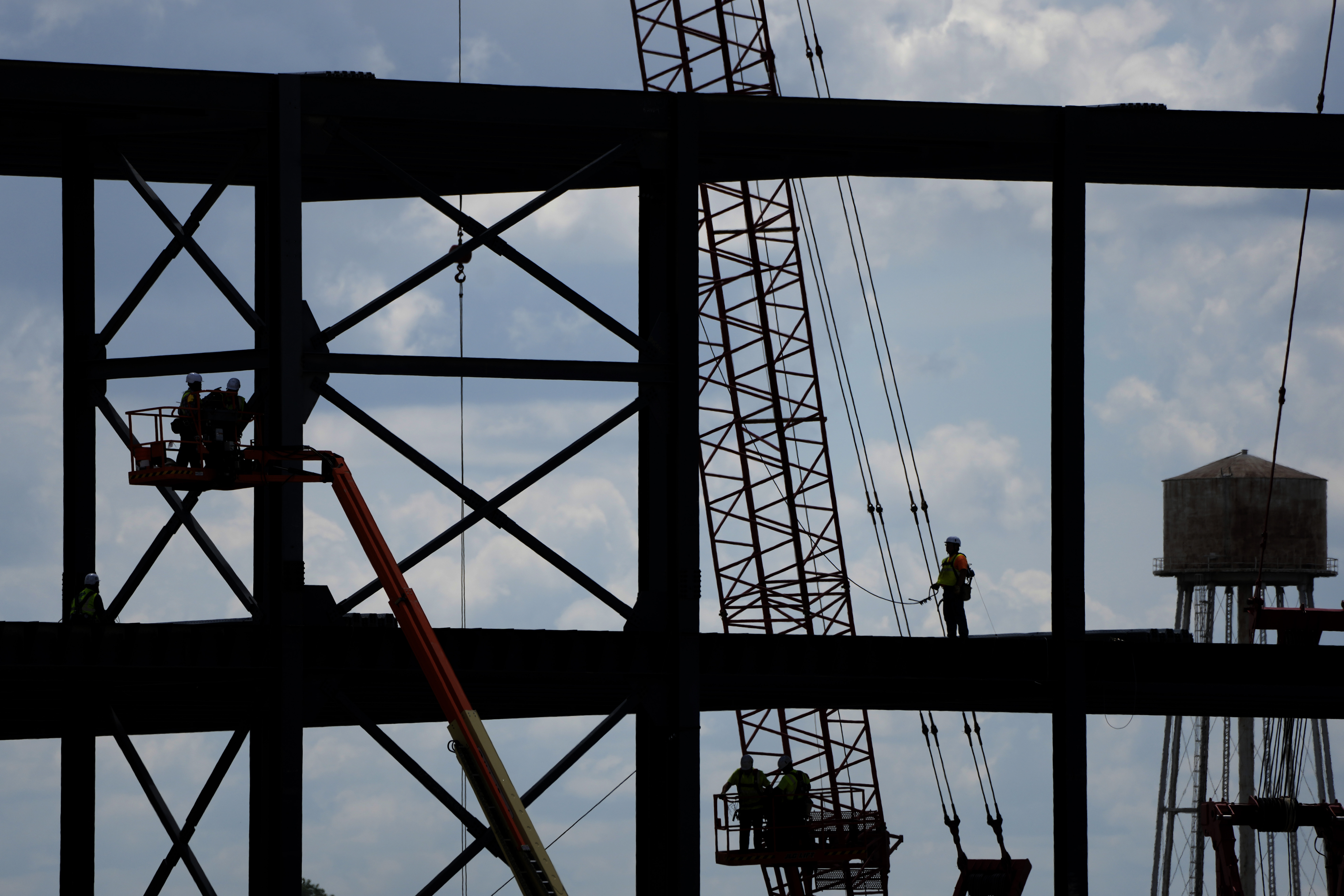 Iron workers construct the frame of a Panasonic electric vehicle battery plant in 2023 near DeSoto, Kansas. Iron workers construct the frame of a Panasonic electric vehicle battery plant in 2023 near DeSoto, Kansas.